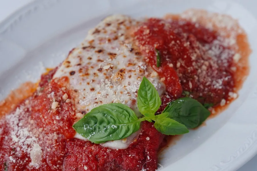 Chicken Parmesan with marinara and cheese — representative food photograph