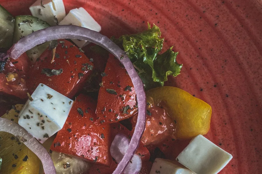 Greek salad on a red plate — representative food photograph
