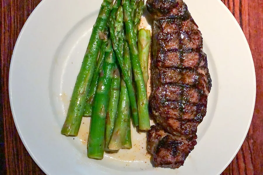 Grilled New York strip steak with asparagus — representative food photograph